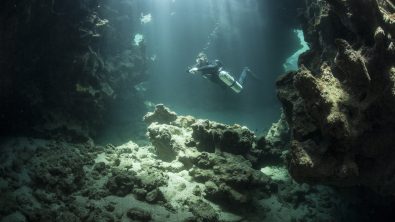 tec diver in light surrounded by rock