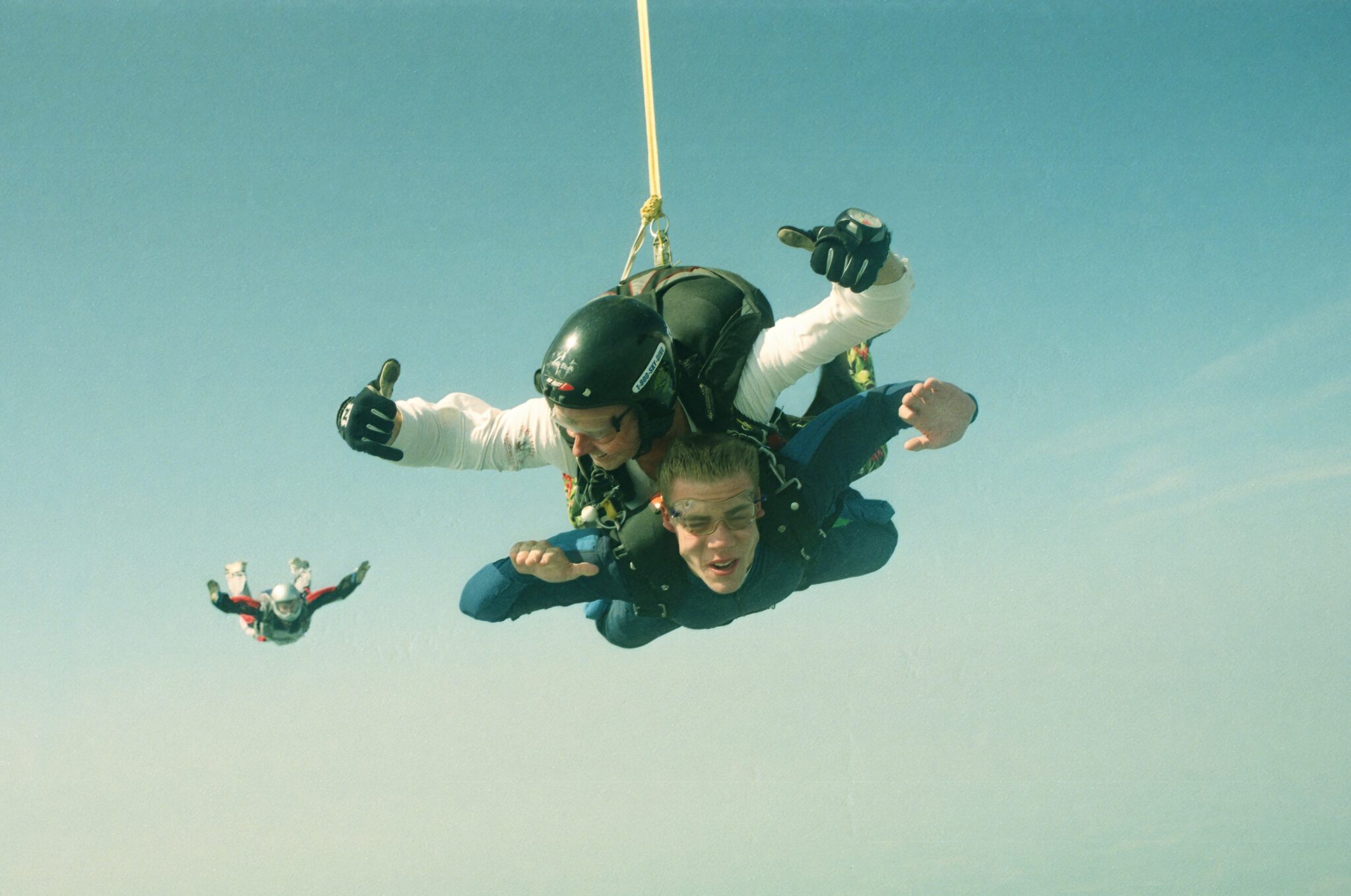 two men skydive in tandem from an airplane