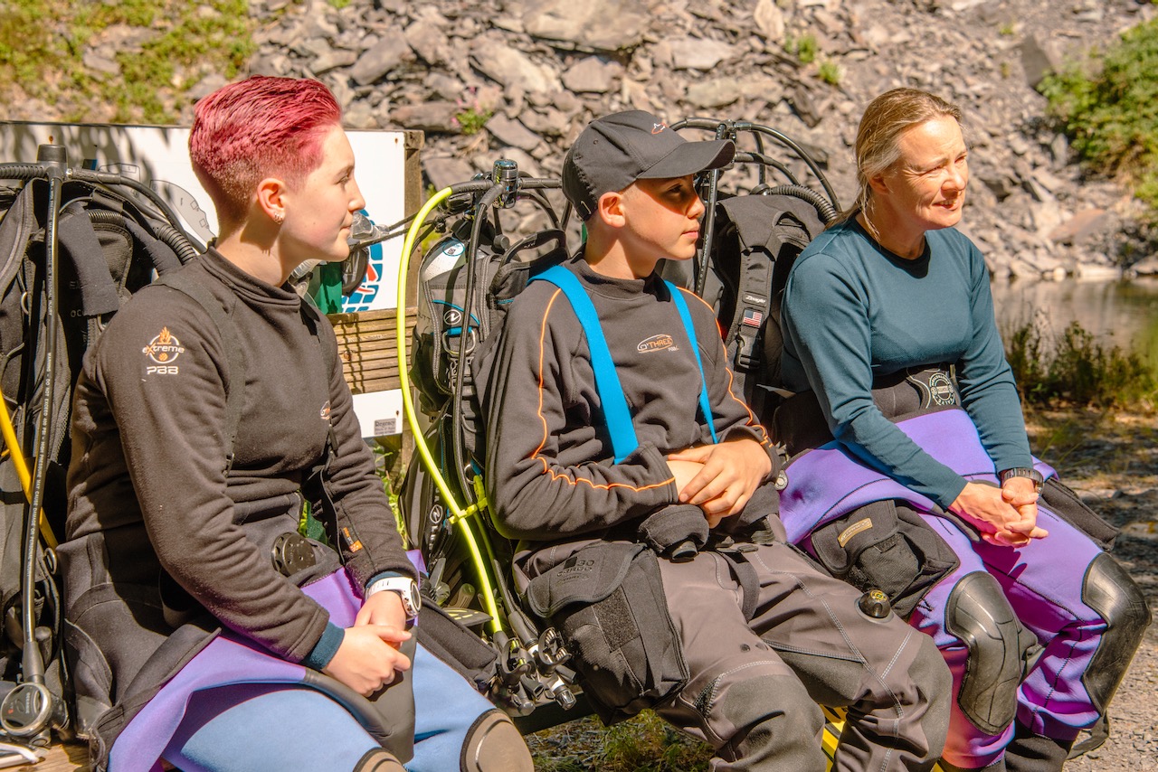 three rescue diver students listen to their padi instructor