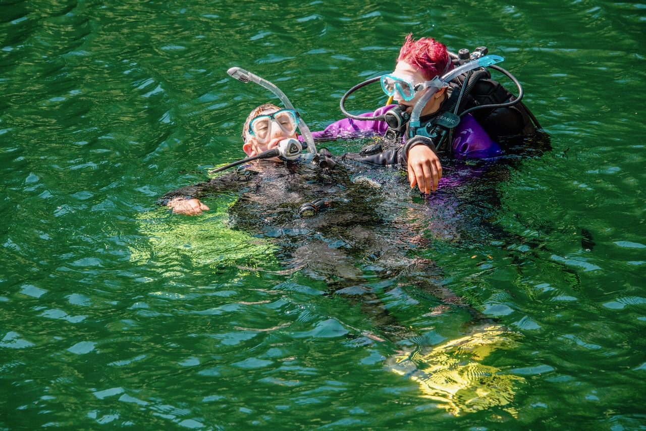 A diver gets towed by another diver during a PADI Rescue Diver course