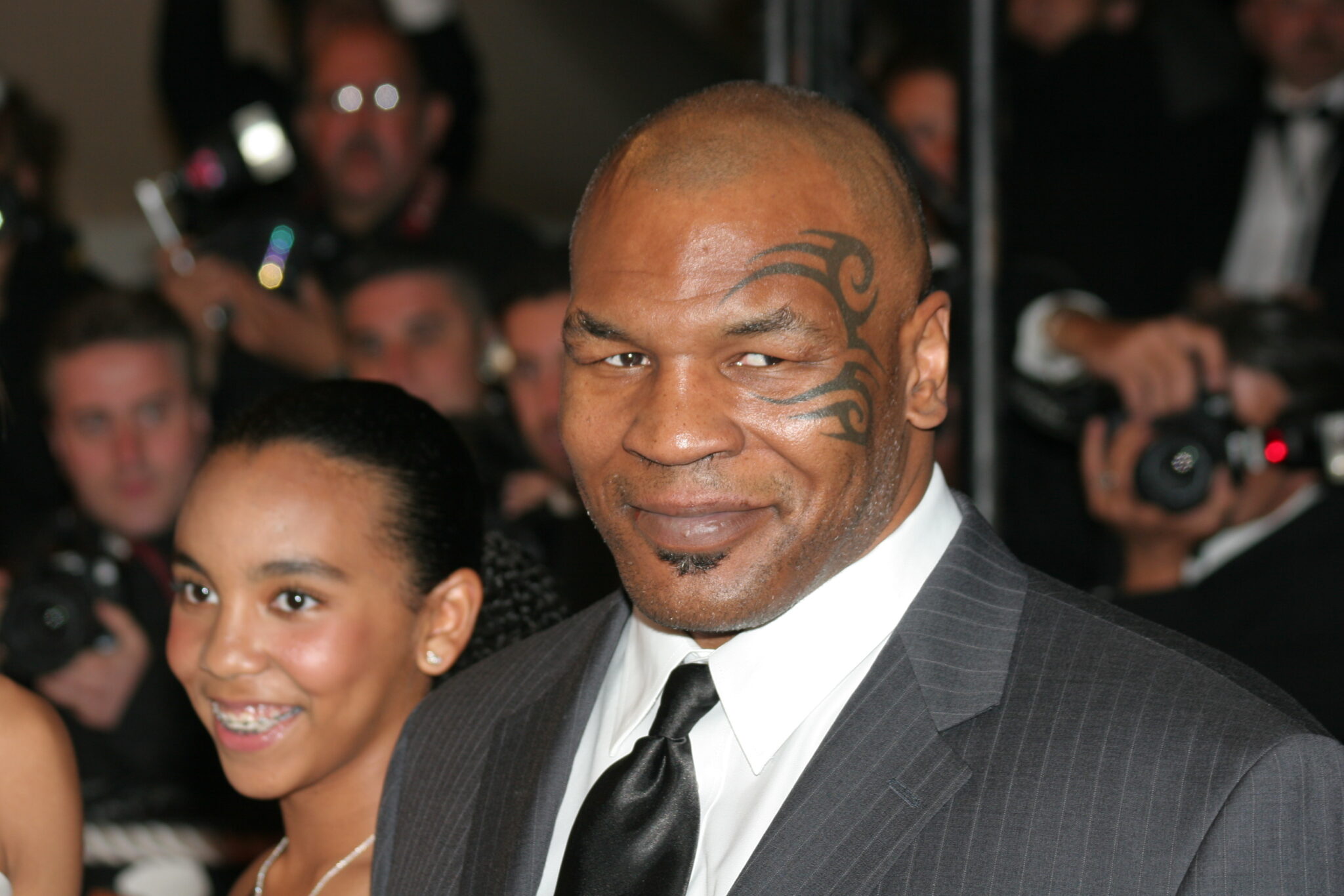 Mike Tyson is photographed at an event with lots of people in the background