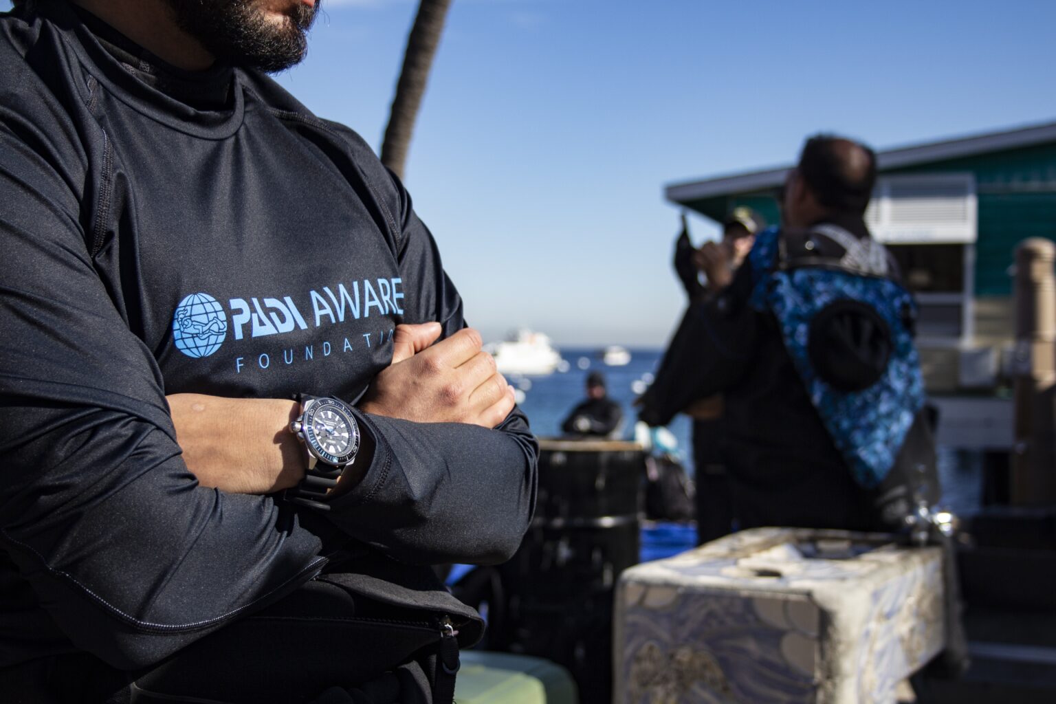 a diver wearing a padi aware rashguard and a seiko watch