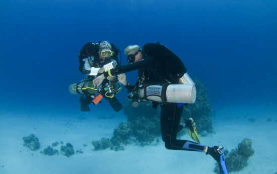 two tec divers communicate underwater