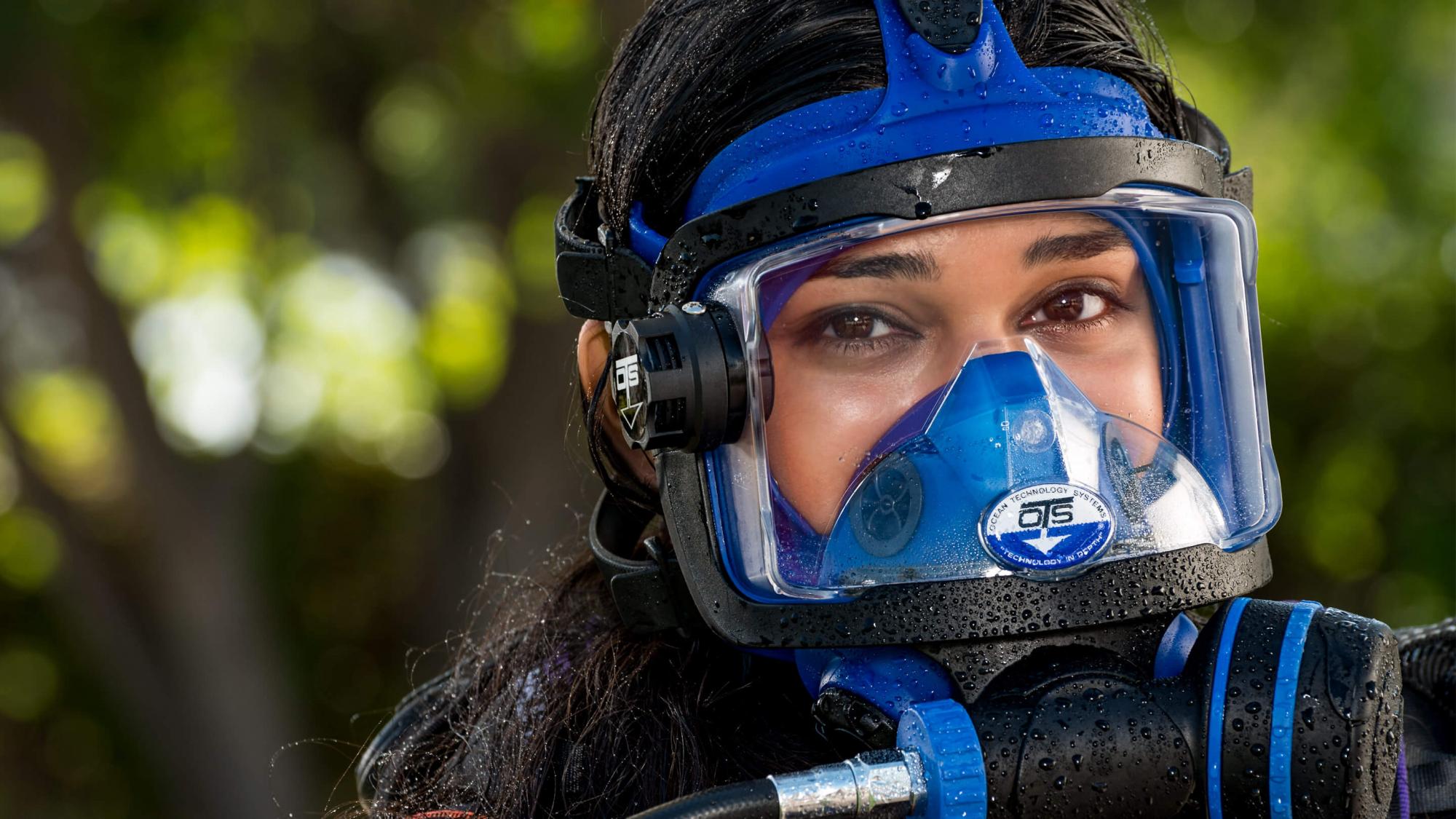 A woman wears a full face mask for scuba diving