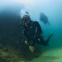 two divers scuba dive in Cabo in medium visibility