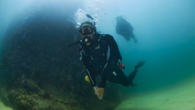two divers scuba dive in Cabo in medium visibility