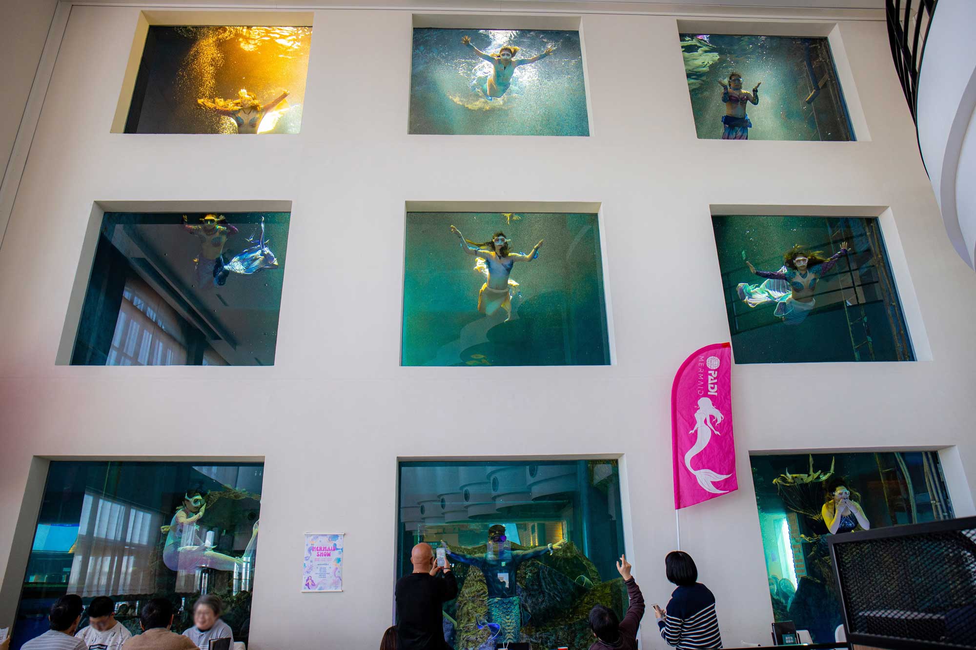 mermaids are performing in the pool inside restaurant