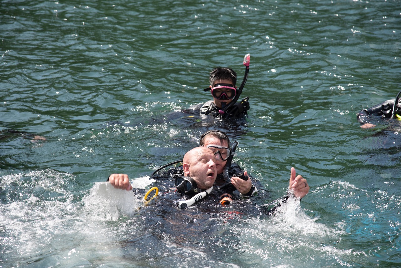 A diver assists a panicked diver at the surface