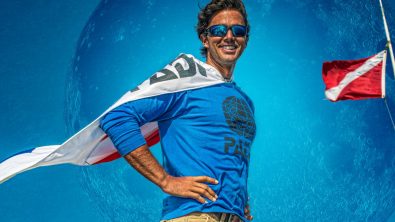 man draped in padi flag standing in a superhero pose