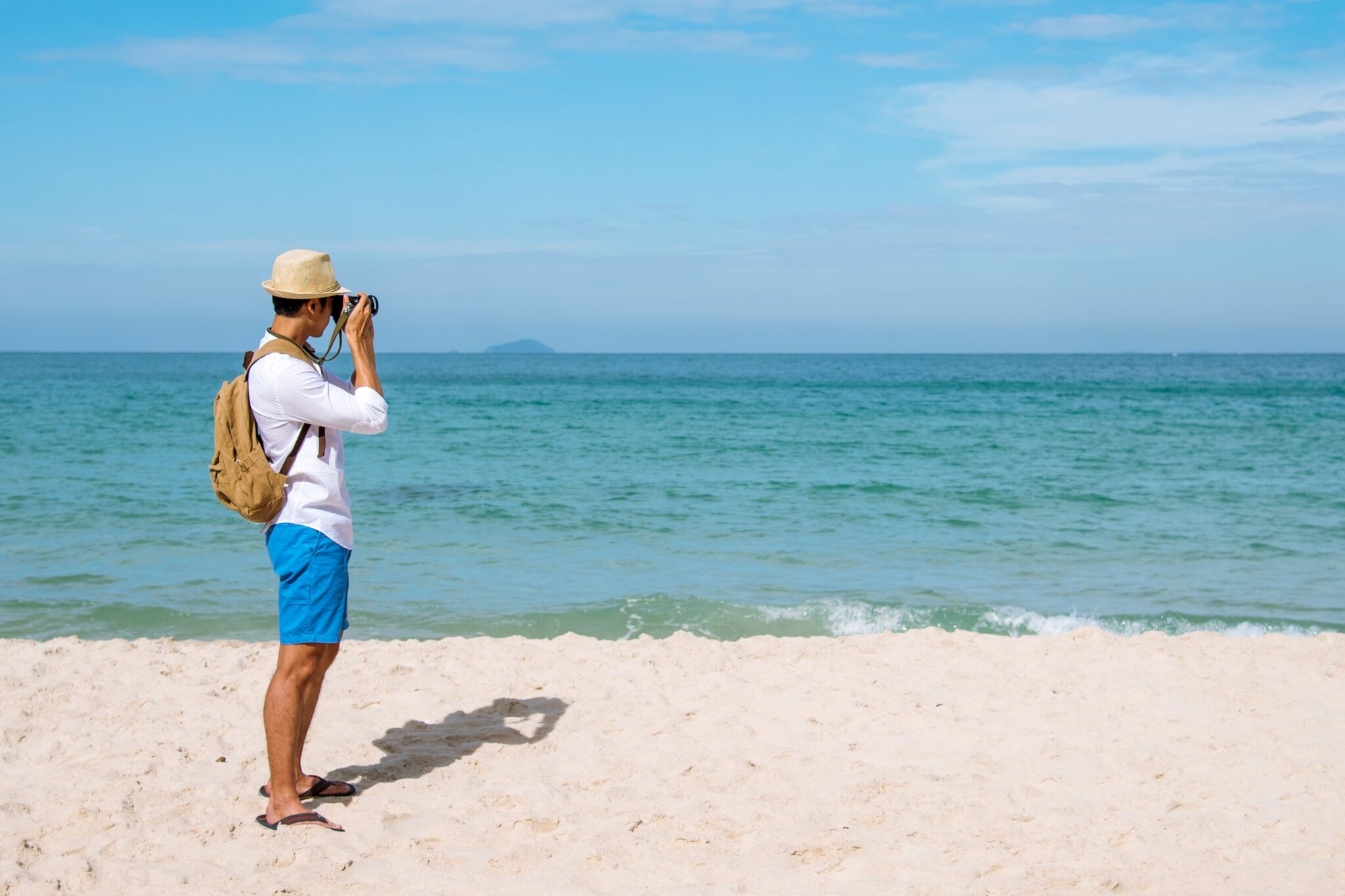 A man on the beach taking photos of the sea