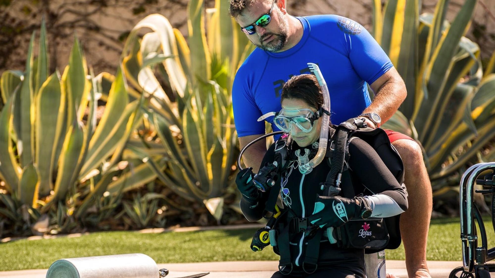 adaptive diving student diver sitting on a poolside