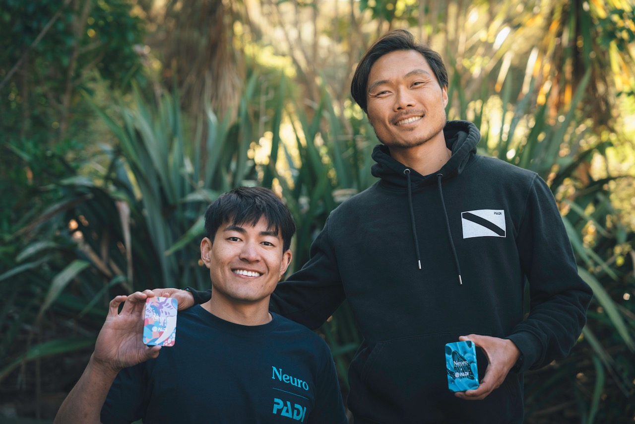 The founders of Neuro hold up the Neuro x PADI tins