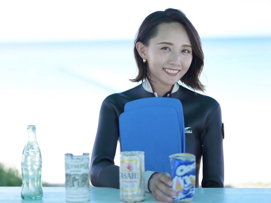 Japan AmbassaDiver Manami Azuma posing with bottles she collected underwater in Okinawa. 