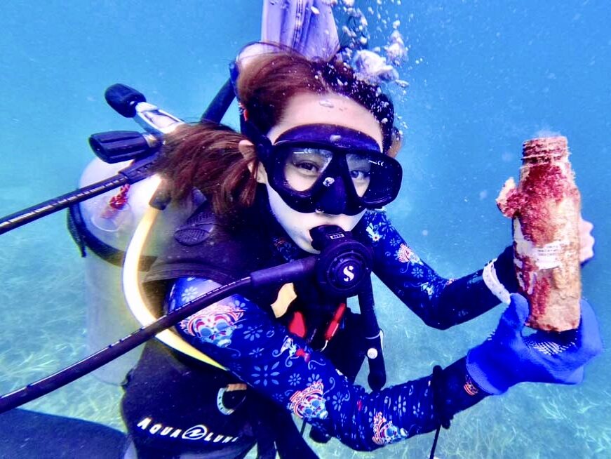 Japan AmbassaDiver Manami Azuma posing underwater in Okinawa while doing underwater clean up. 