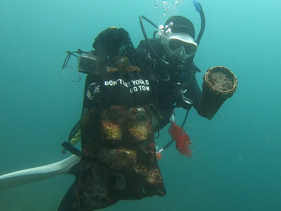 Japan AmbassaDiver Yumi Shirai doing a clean up dive in Izu Japan.