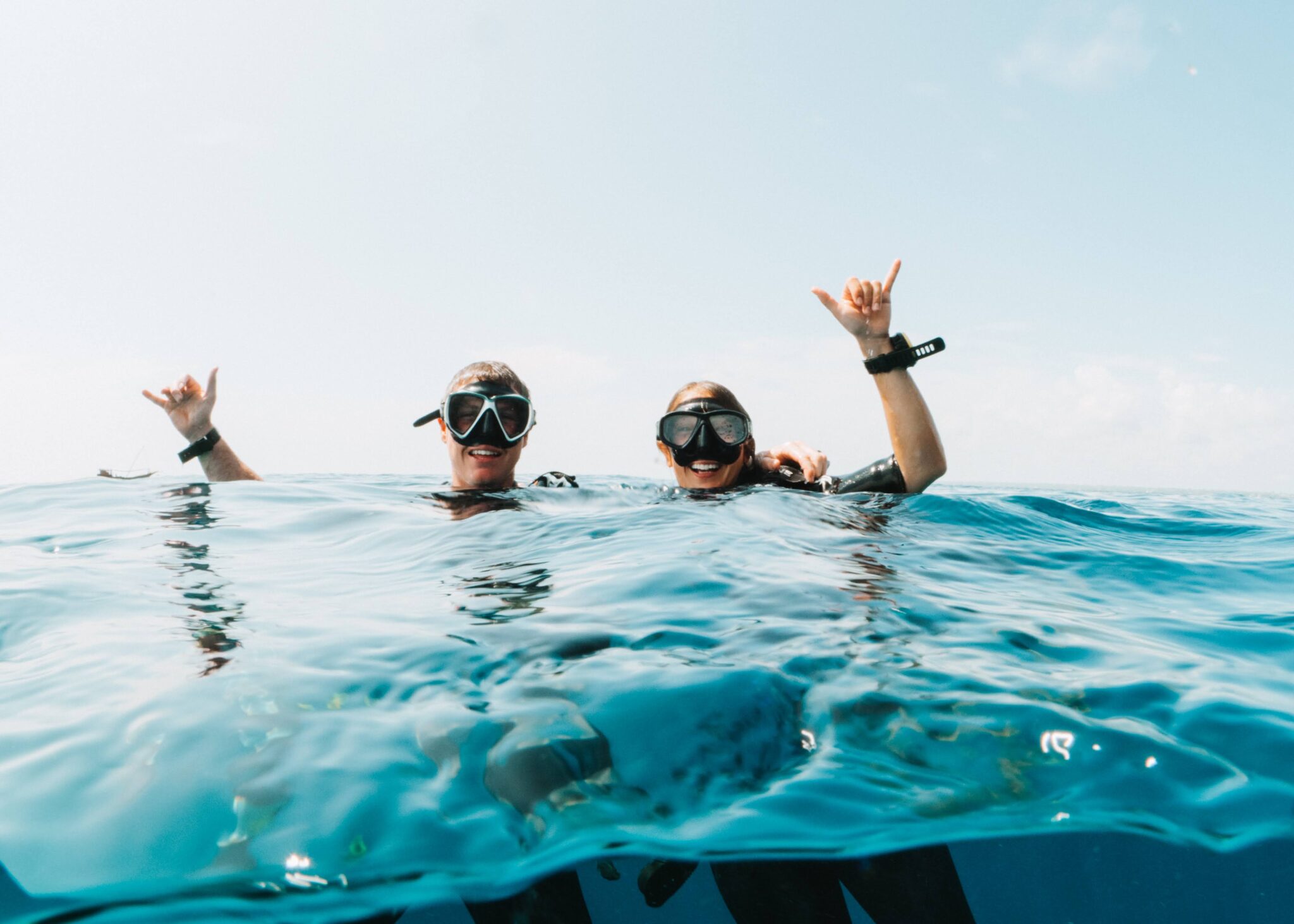 Mary Hannah and her husband give the hang loose signs from the water's surface after a scuba dive