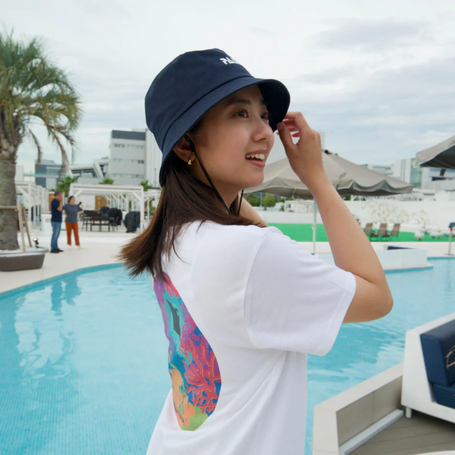 a woman by the pool wearing PADI bucket hat