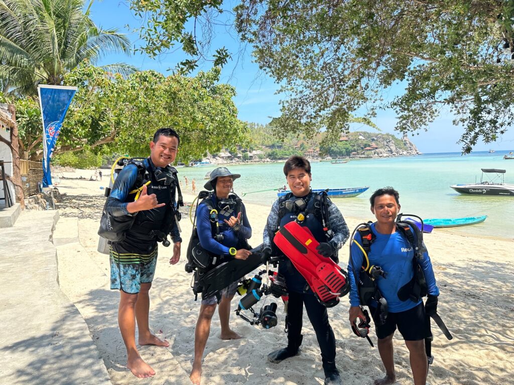 Big Bubble Dive crew pose on the beach in diving gear
