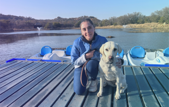 Jessica Pita with her dog Fudge smiling to the camera on a dock