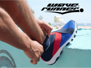 A man puts on his wave runner shoes before going to the beach