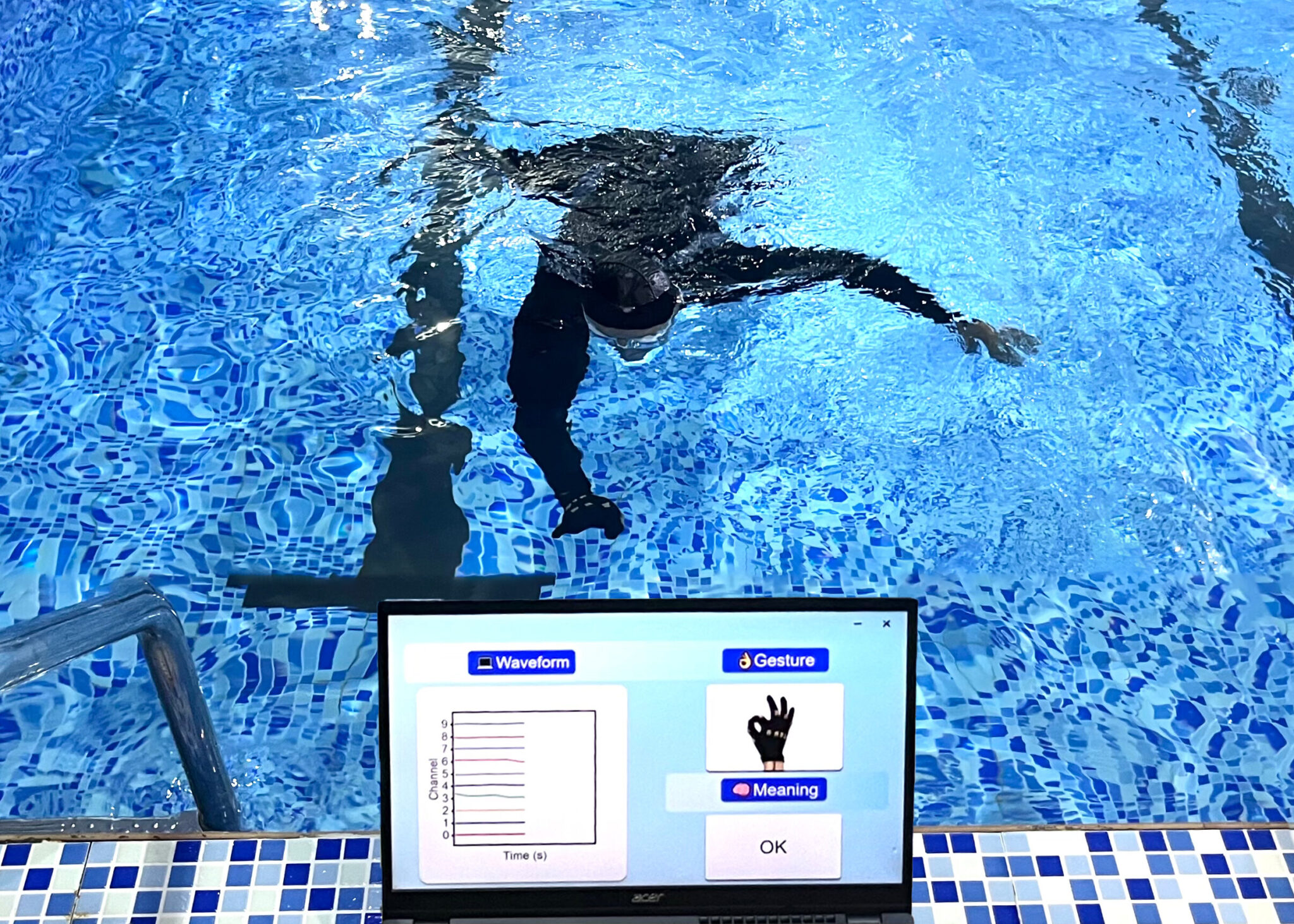 swimmer in pool wearing an e-glove for underwater communication