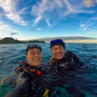 two divers taking a selfie at the surface