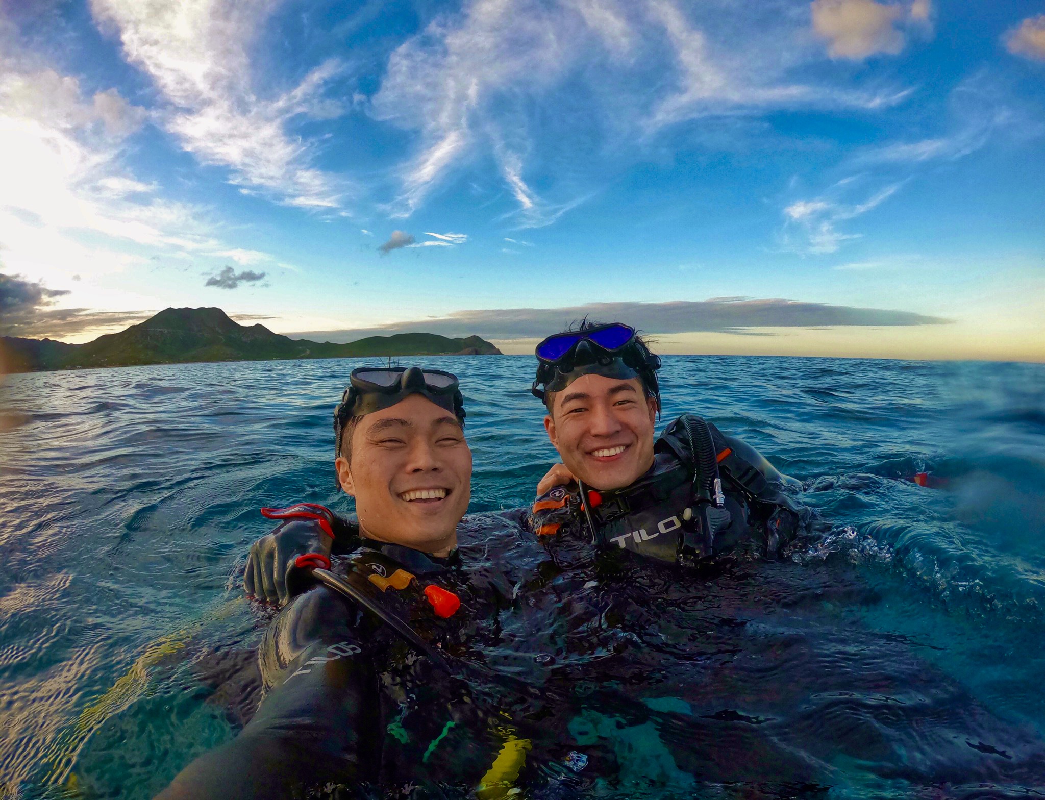 two divers taking a selfie at the surface