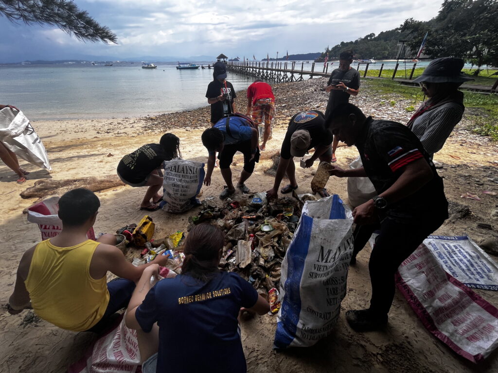 A group of people collect garbage on the beach