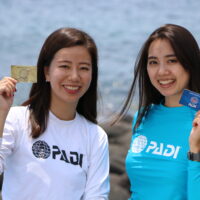 two ladies holding PADI standard c card on land