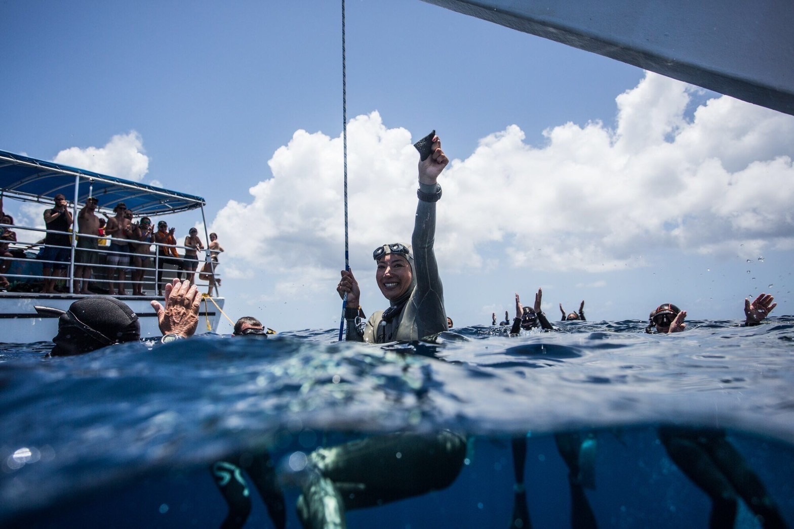 an athelete freediver expressing her joy on the surface