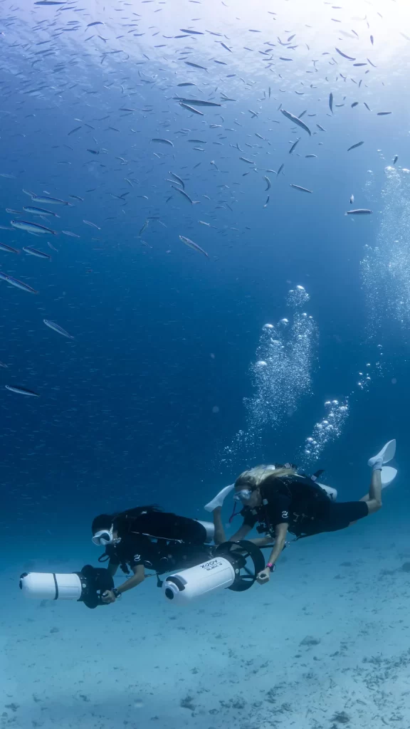 يستخدم غواصان مركبة دفع الغواص أثناء استكشاف العالم تحت الماء حول منتجع وسبا جزيرة فيلاميندهو
