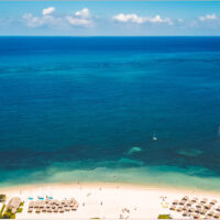 Clear, blue water and a sandy beach with umbrellas in Montego Bay Jamaica