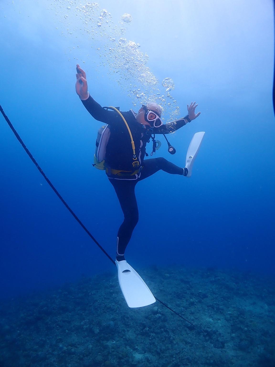 a diver tightrope walking using anchor line.