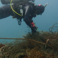 Scuba diver removing ghost fishing net.