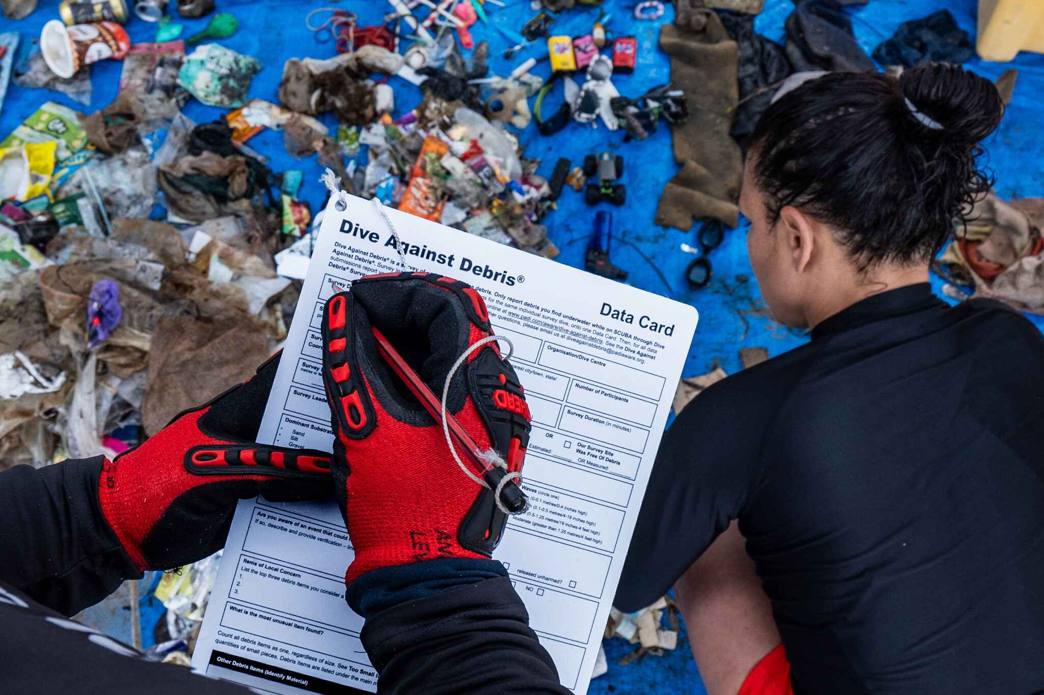 Het team van Dive Against Debris houdt plastic afval bij dat ze tijdens een schoonmaakactie hebben gevonden.