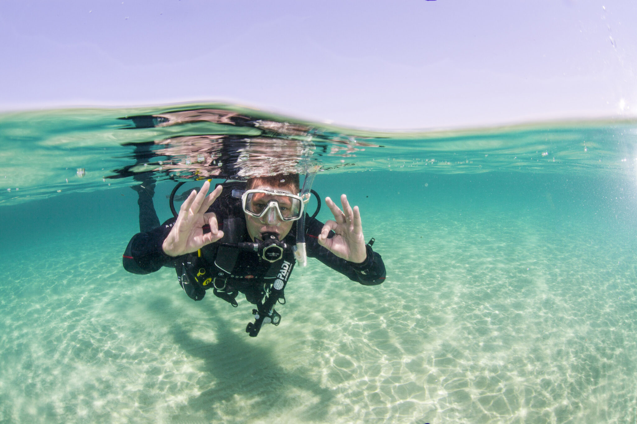 a diver doing okay sign underwater