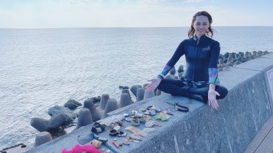 diver posing with trash collected from underwater, okinawa, japan