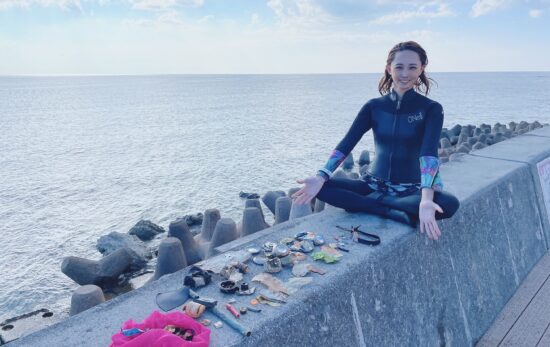 diver posing with trash collected from underwater, okinawa, japan