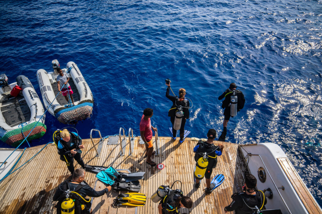 Taucher auf einem Safariboot beginnen Tauchgang.