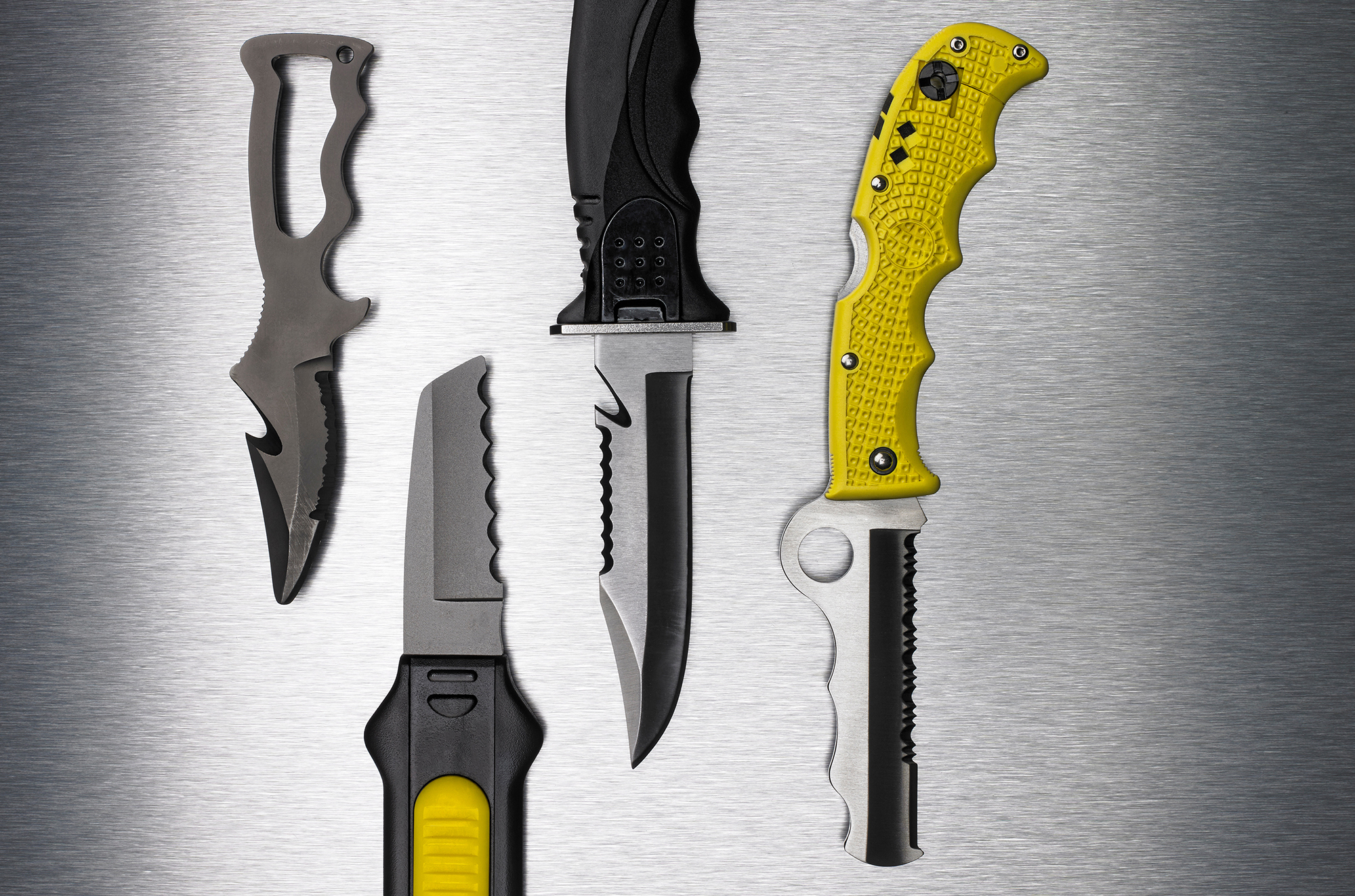 Four different dive knives showing examples of blade styles, a deciding factor when choosing the best scuba knives