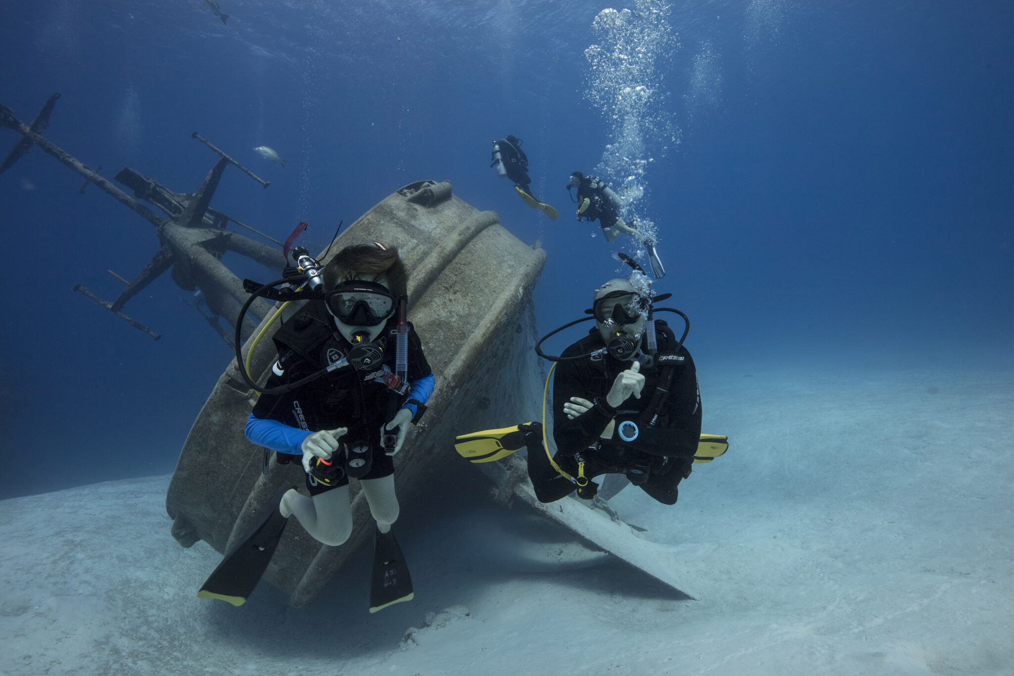 a PADI Instructor takes a child scuba diving at a wreck in Grand Cayman as a part of the PADI Open Water Diver course