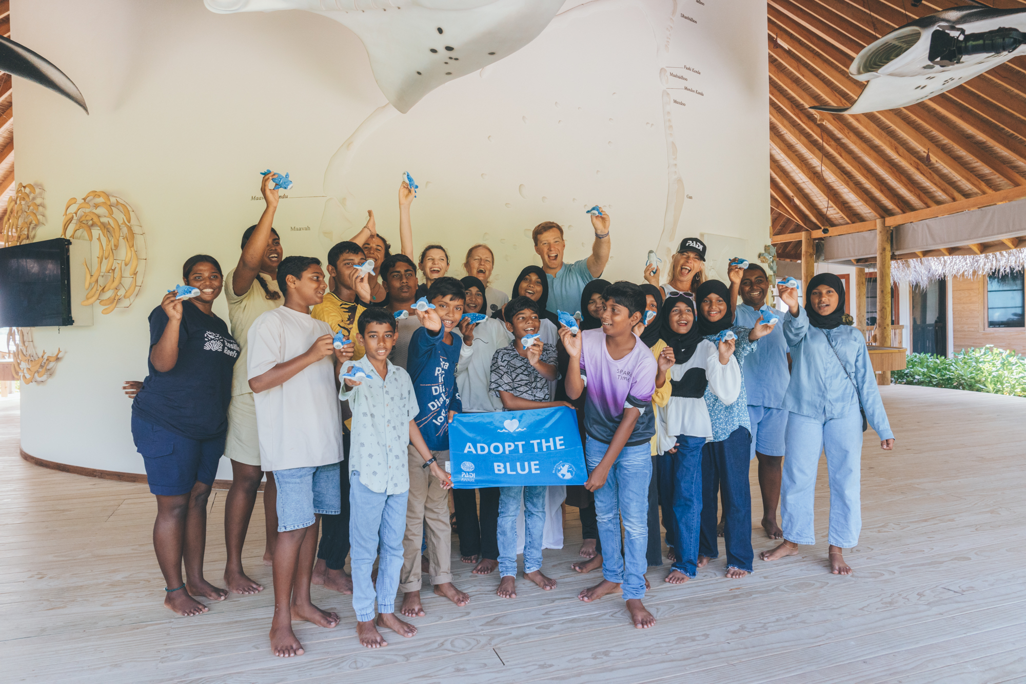 a group of people smile for the camera while holding a padi aware flag