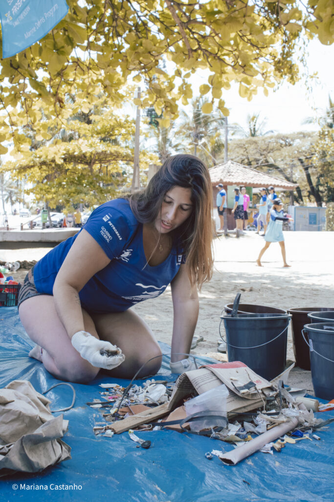 A woman wearing gloves sorts marine debris