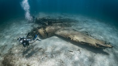 two scuba divers explore an airplane wreck in the Bahamas