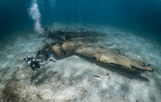 two scuba divers explore an airplane wreck in the Bahamas