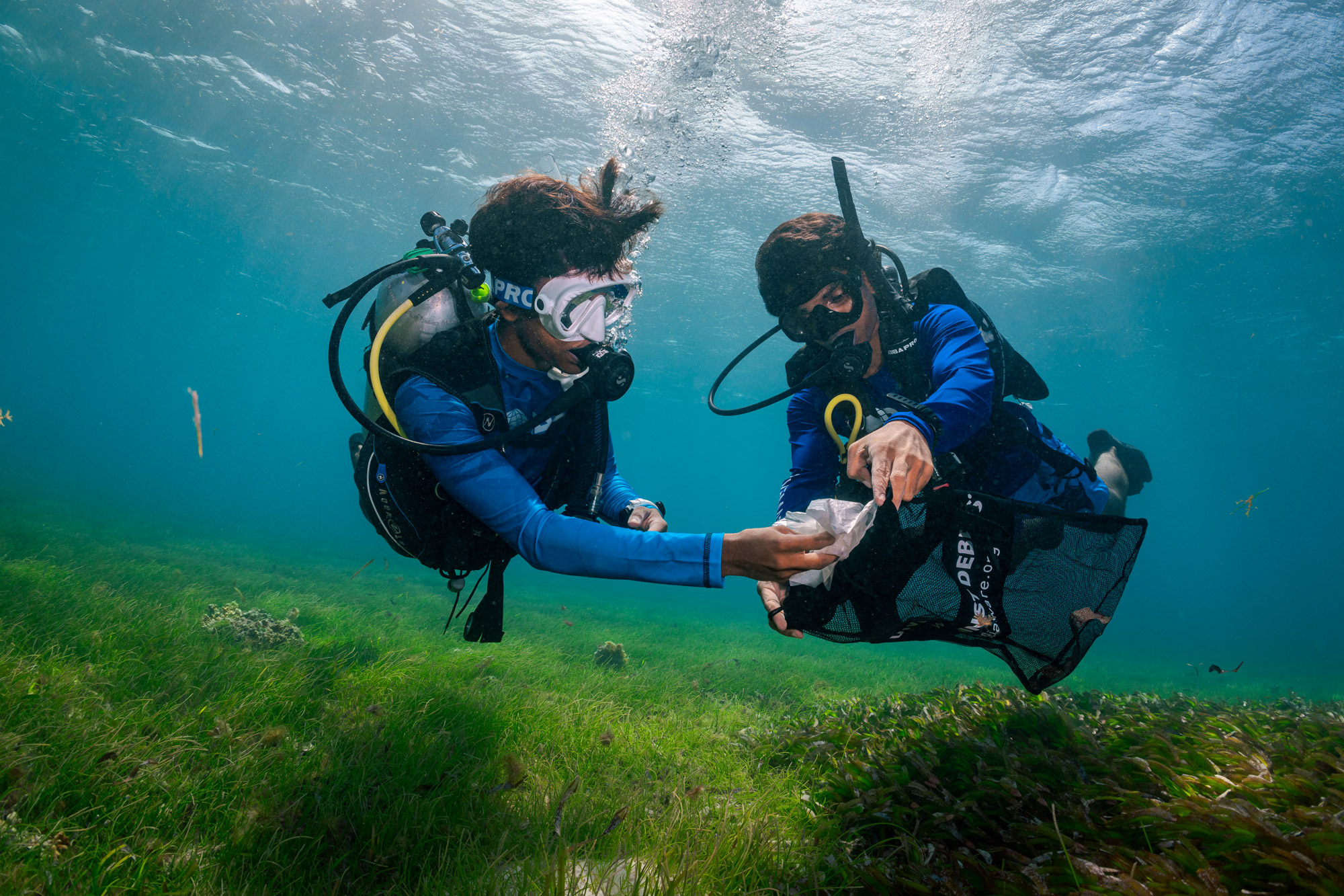 Twee duikers verzamelen afval tijdens een Dive Against Debris-duik