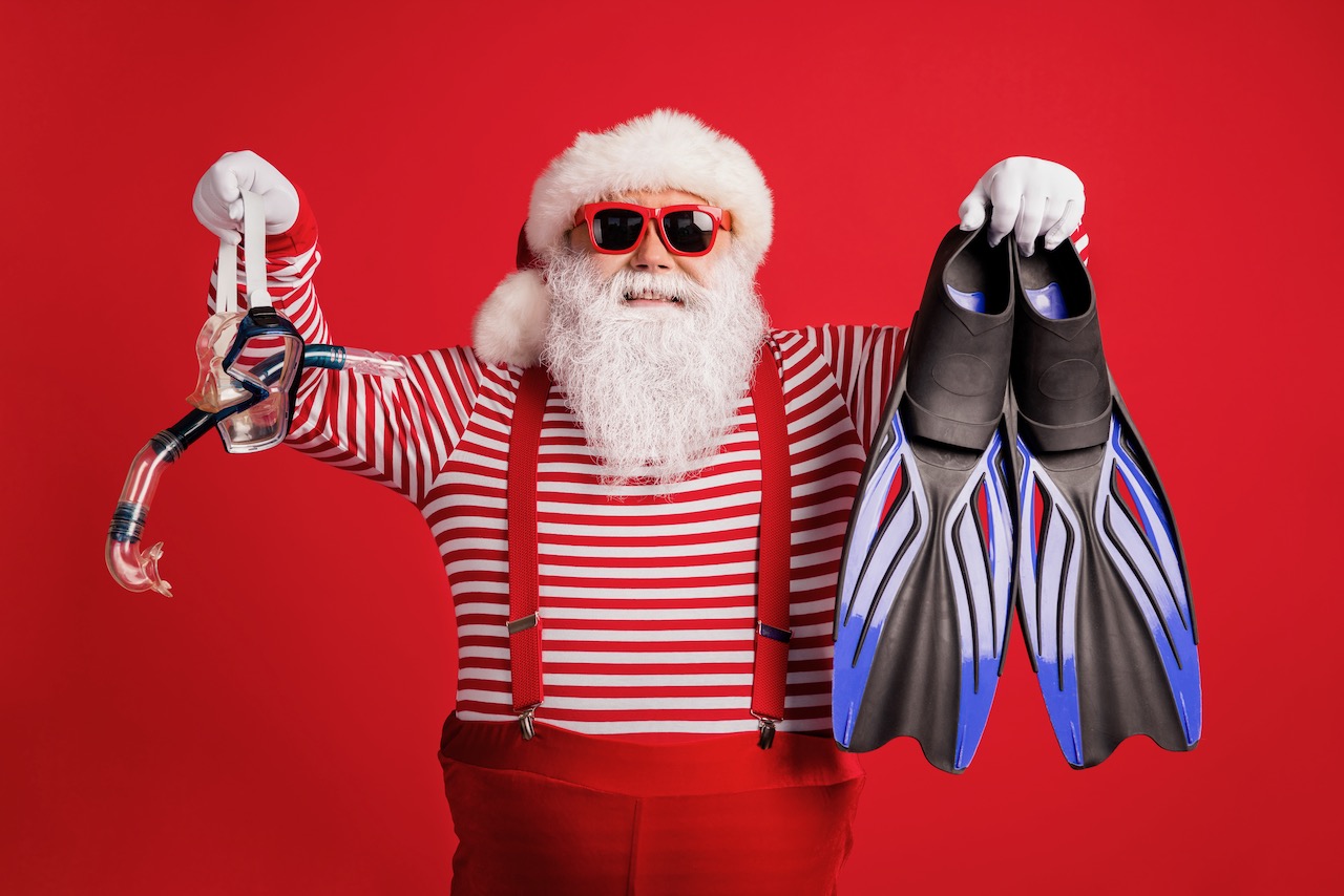 santa holding a pair of fins and a mask