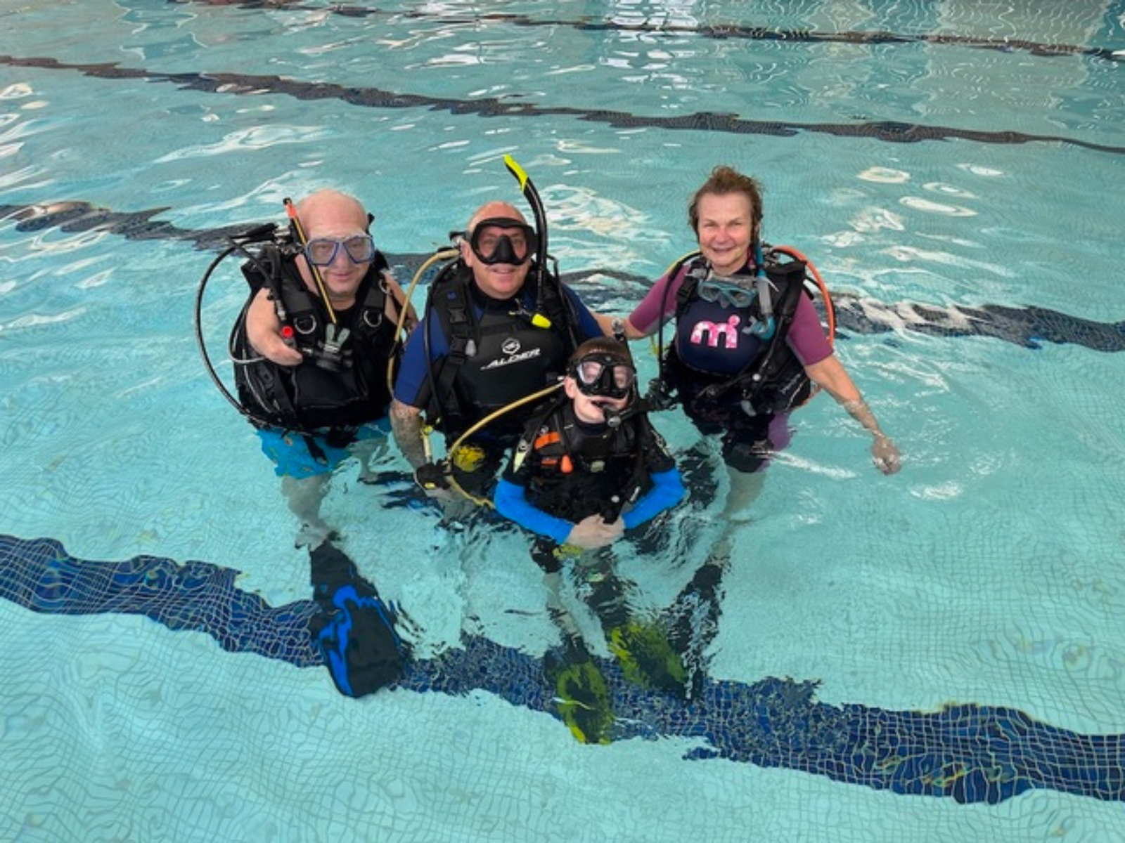 Nic Carapanagiotu and diving students in swimming pool