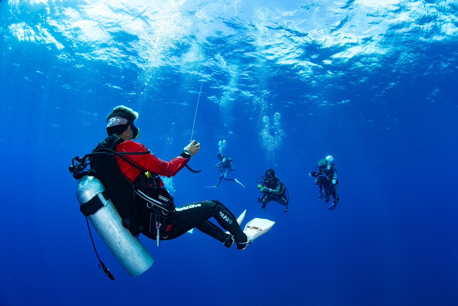 a dive guide leading 3 divers 