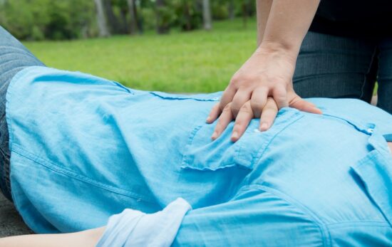 CPR, Resuscitation. Doctor and nurse resuscitated patient in the garden, Nurse giving cardiopulmonary resuscitation (CPR) to a patient outdoor in the park.